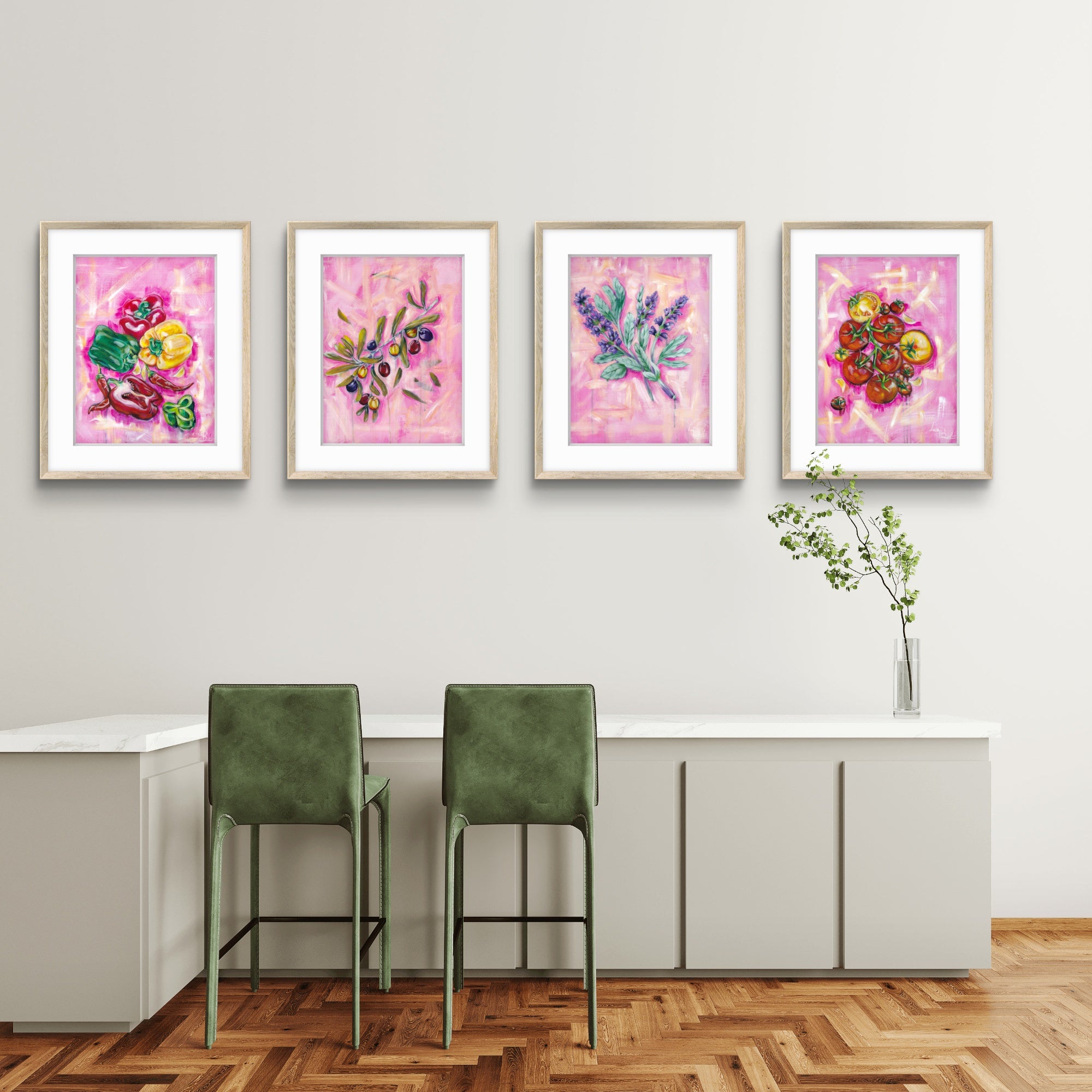 Four framed Luna Burlo kitchen artworks on a wall above a dining table with green chairs.