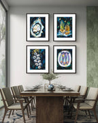 Dining room with a wooden table and chairs, and four framed  Luna Burlo artworks on the wall.