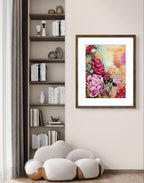 Framed floral artwork on a wall next to a bookshelf with decorative items.