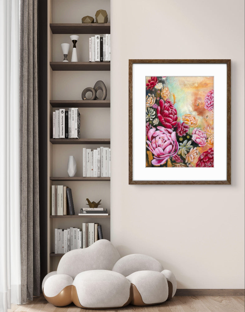 Framed floral artwork on a wall next to a bookshelf with decorative items.