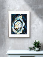Framed Luna Burlo abstract art piece on a gray wall with a white cabinet and plants below.