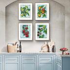 Kitchen with light blue cabinets and framed Luna Burlo artwork of fruits on a gray wall.
