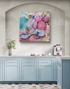 Colorful floral painting above a kitchen counter with cabinets and appliances.