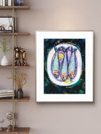 Framed Luna Burlo artwork of three sardine fish with a colorful background on a wall beside a wooden shelf.