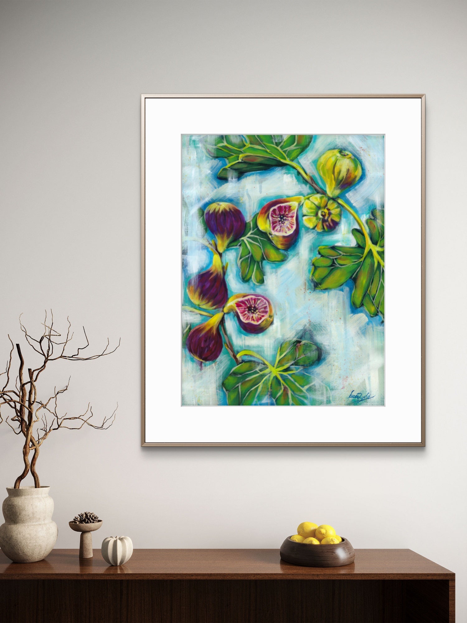 Framed Luna Burlo artwork of figs and leaves on a wall above a wooden console table.