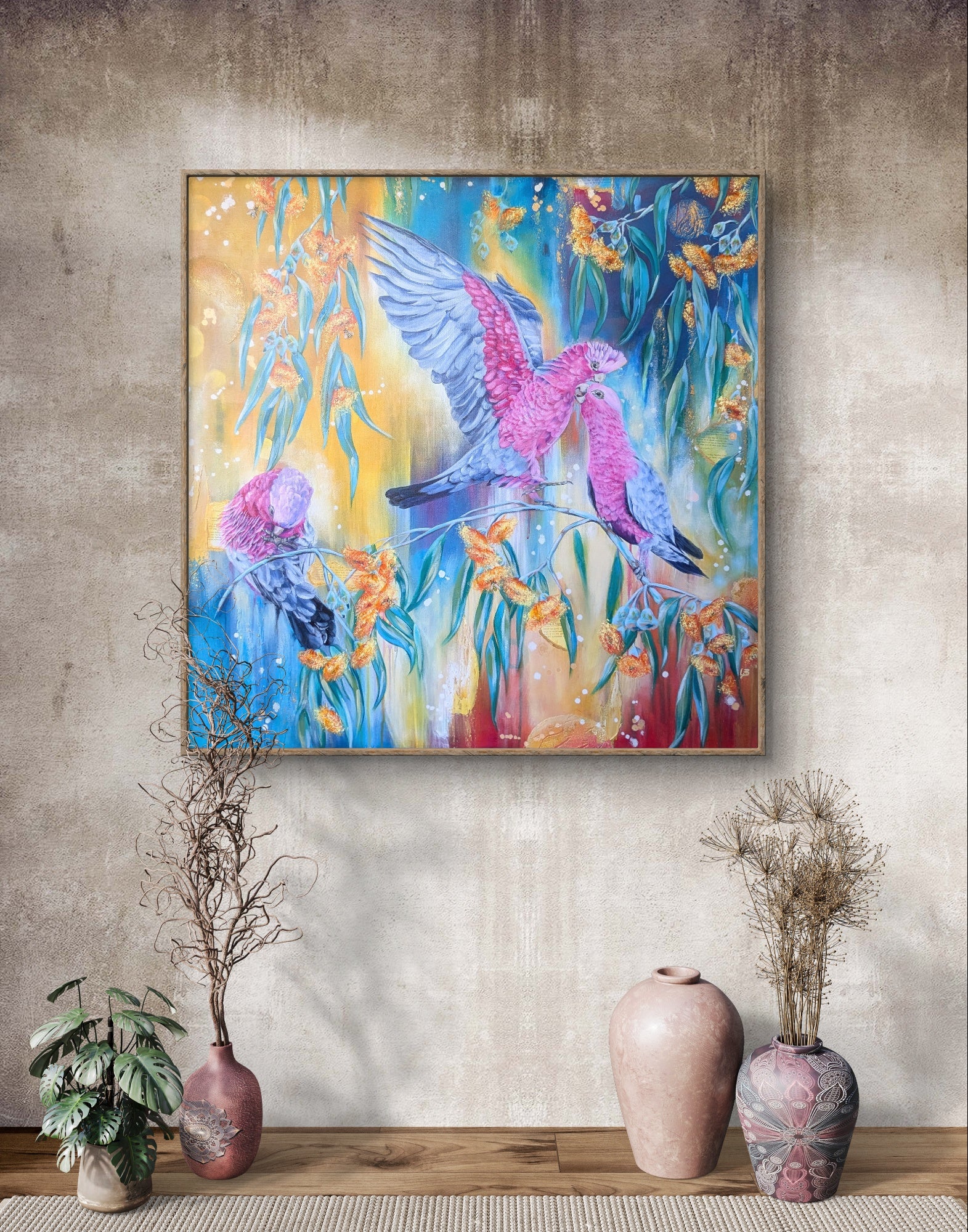 Large colorful abstract painting or fine art print of Australian galah birds in eucalyptus trees on a modern wall with decorative vases and indoor plants below. Artist, Luna Burlo, Melbourne, Australia