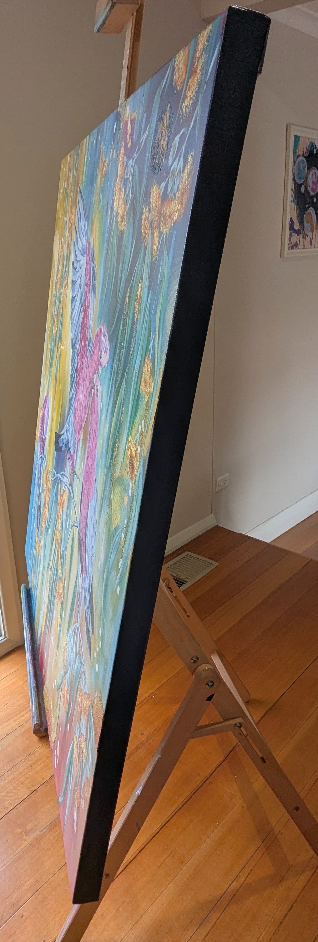 "blush in the Branches", a colorful textured, mixed media, abstract painting on easel indoors. Inside artist, Luna Burlo's, Melbourne, Australia, studio