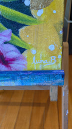 Flourish Luna Burlo Painting canvas with a painting of a yellow flower and signature 'luna B.' on a wooden floor.