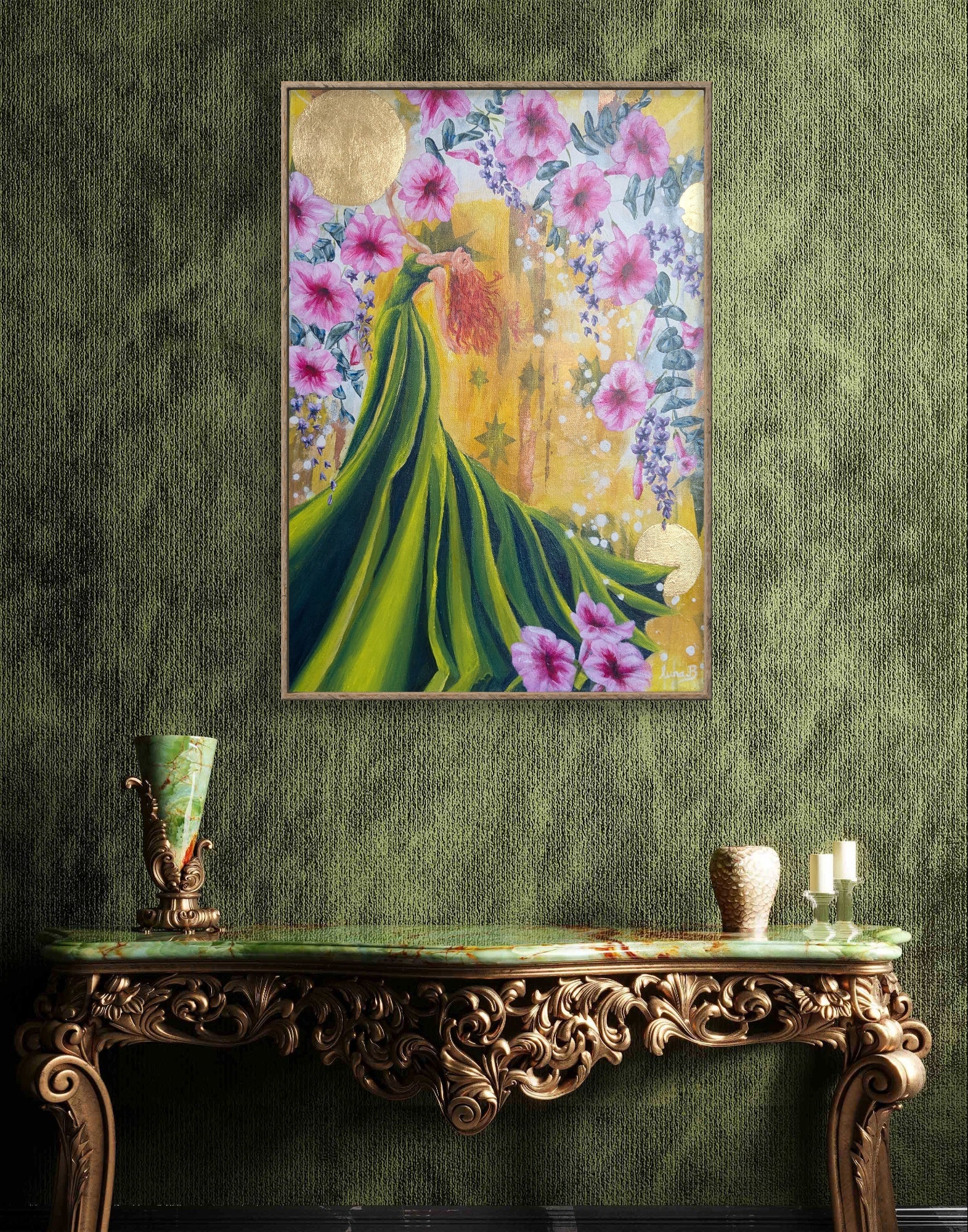 Framed Luna Burlo artwork of a woman in a green dress with flowers on a green wall above an ornate console table.