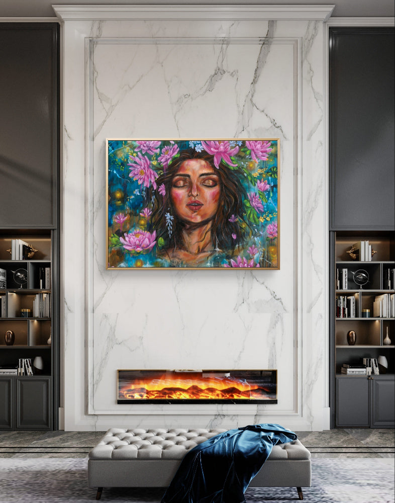 Large framed fine art canvas print artwork of a woman with pink lotus flowers and blue background on a marble wall above an electric fireplace in a living room. Art by Luna Burlo, Melbourne, Australia
