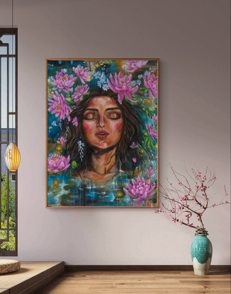 Colorful painting of a woman's face with pink lotus flowers and blue background on a spa-like retreat wall in a room with a vase and branches. Artwork by Luna Burlo and made in Melbourne, Australia