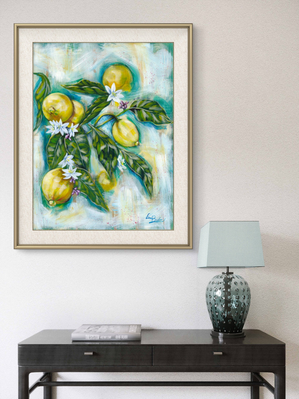 Framed Luna Burlo food art painting of lemons and flowers on a white living room or hallway wall above a console table with a lamp.

Luna Burlo fine art paper print or her original artwork of Lemons from series "Mediterranean Table".

Colorful abstract with yellow fruit, white flowers, vibrant green leaves, and turquoise blue background. Rectangle vertical or portrait orientation. Made in Melbourne, Australia